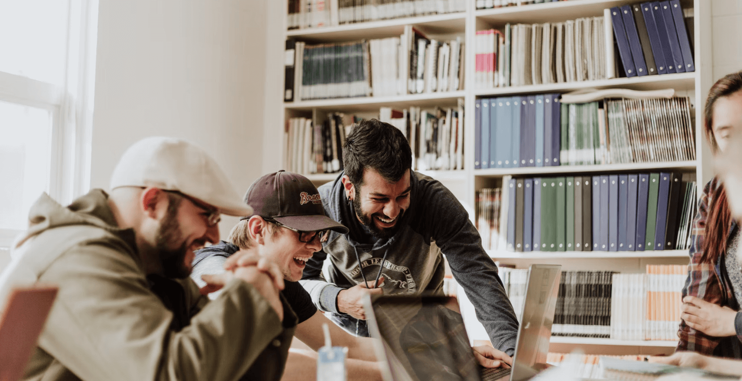 Three young men looking at a laptop